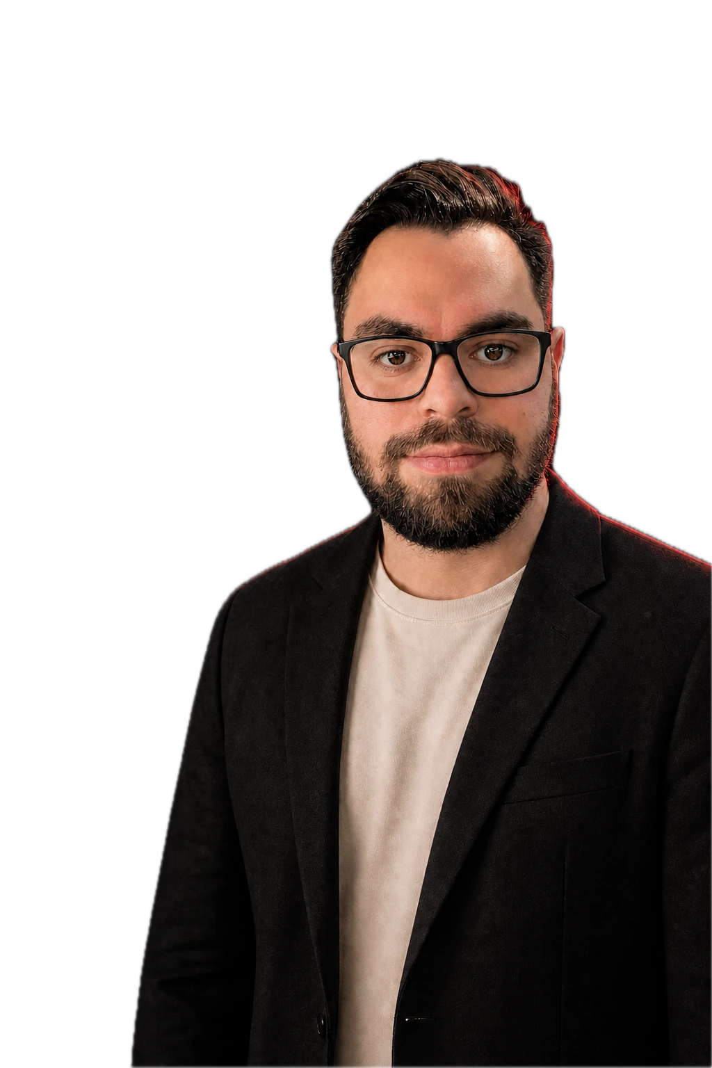 Harrison Olvera wearing black glasses, a charcoal blazer, and a warm off-white crewneck under red and blue studio lighting